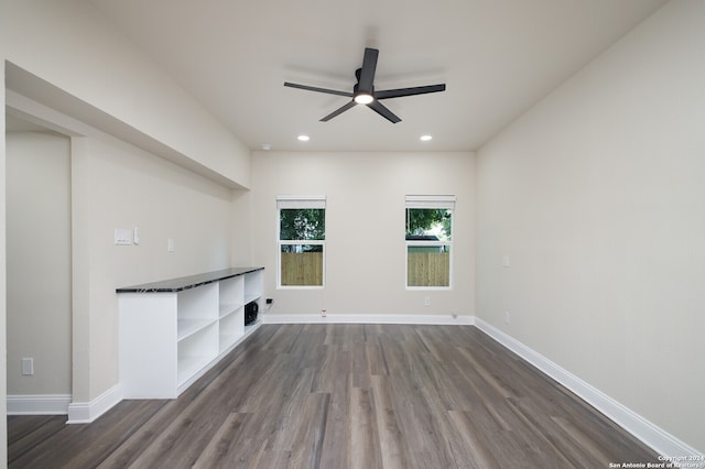 unfurnished living room with ceiling fan and dark wood-type flooring