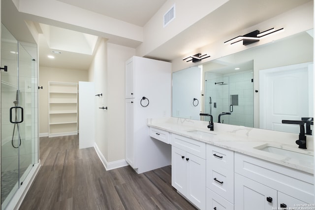 bathroom with an enclosed shower, dual vanity, and hardwood / wood-style flooring