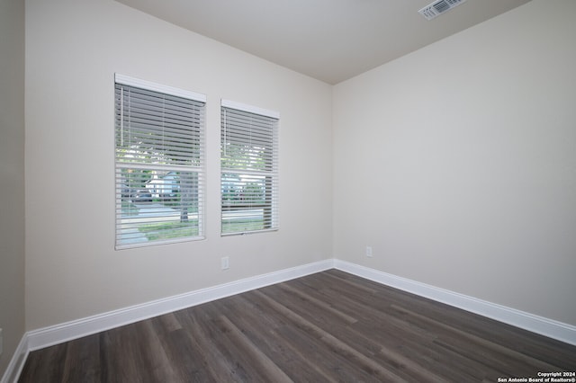 unfurnished room with dark wood-type flooring