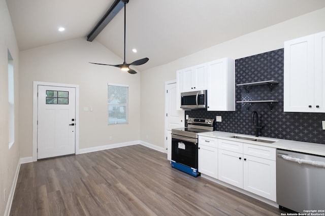 kitchen featuring ceiling fan, wood-type flooring, appliances with stainless steel finishes, sink, and beamed ceiling