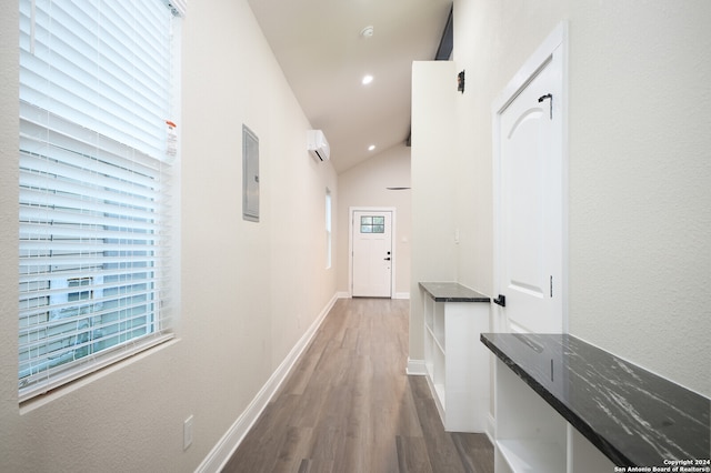 hall featuring lofted ceiling, wood-type flooring, electric panel, and a healthy amount of sunlight