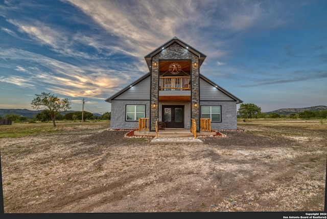 136 Cardinal Dr, Camp Wood, TX 78833 - rear view of house featuring a mountain view, french doors, a balcony, and stone siding