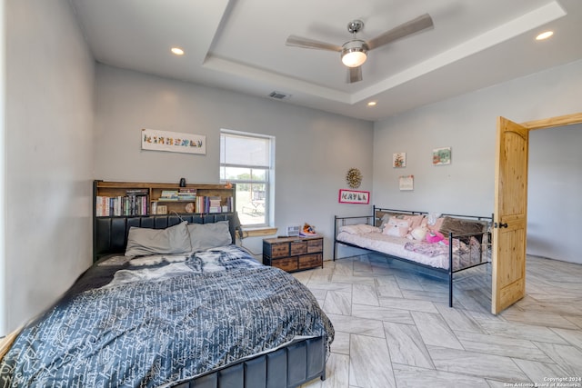 bedroom featuring a tray ceiling and ceiling fan