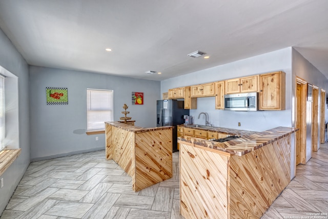 kitchen with sink, light brown cabinets, and light parquet floors