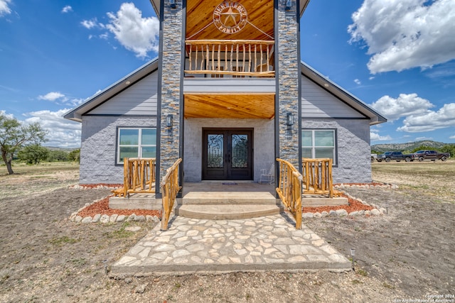 property entrance with a balcony and french doors