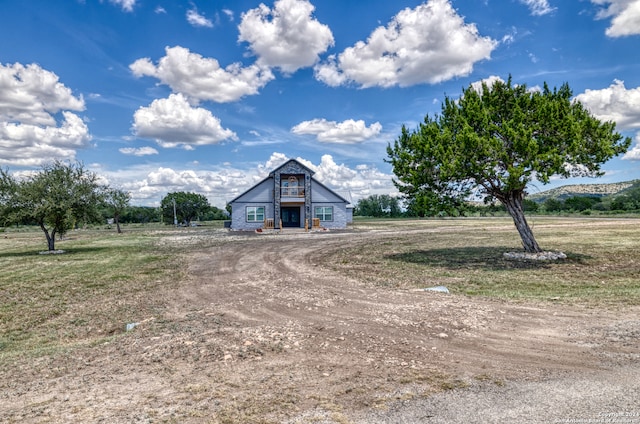 view of front of home with a rural view and an outbuilding