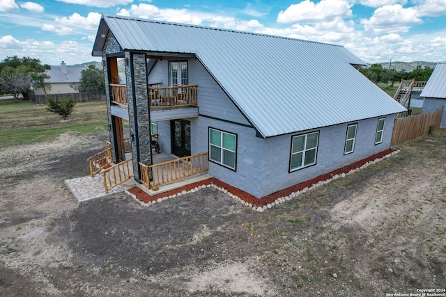 136 Cardinal Dr, Camp Wood, TX 78833 - back of property featuring metal roof, fence, covered porch, and a balcony
