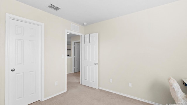 unfurnished bedroom with baseboards, visible vents, and light colored carpet