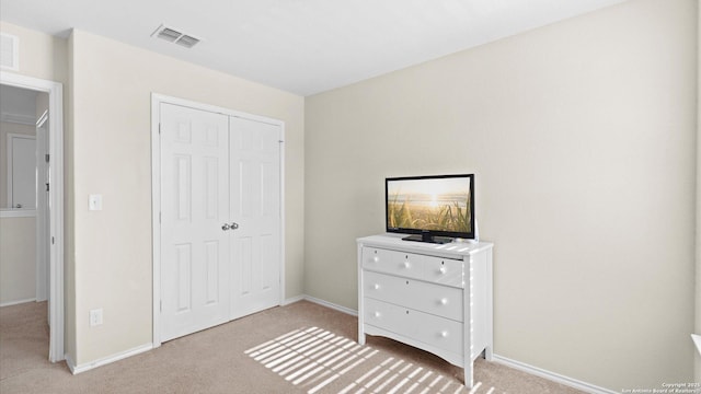 unfurnished bedroom with baseboards, a closet, visible vents, and light colored carpet