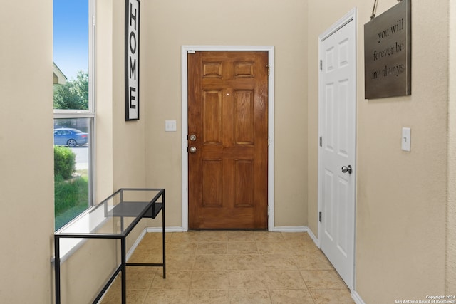 foyer entrance featuring light tile patterned flooring and a healthy amount of sunlight