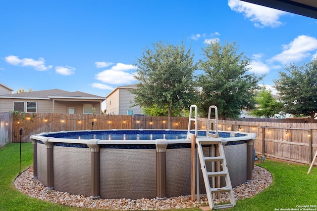 view of pool with a fenced in pool, a fenced backyard, and a yard