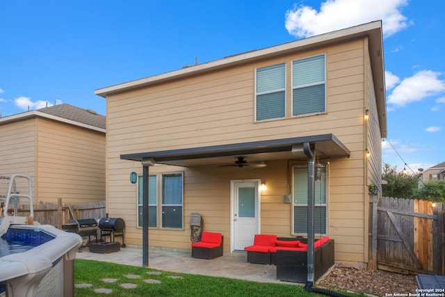 back of property with an outdoor living space, ceiling fan, and a patio