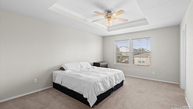 bedroom with ceiling fan, carpet, a raised ceiling, and baseboards