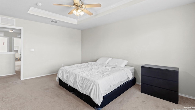 bedroom with carpet, visible vents, a tray ceiling, and ornamental molding