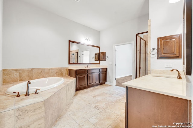 bathroom featuring plus walk in shower, vanity, and tile patterned floors