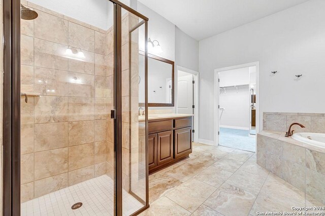 bathroom with tile patterned flooring, independent shower and bath, and vanity