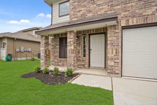 entrance to property with a lawn and a garage