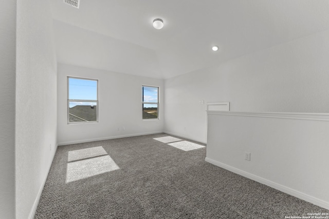 spare room featuring carpet floors, visible vents, and baseboards