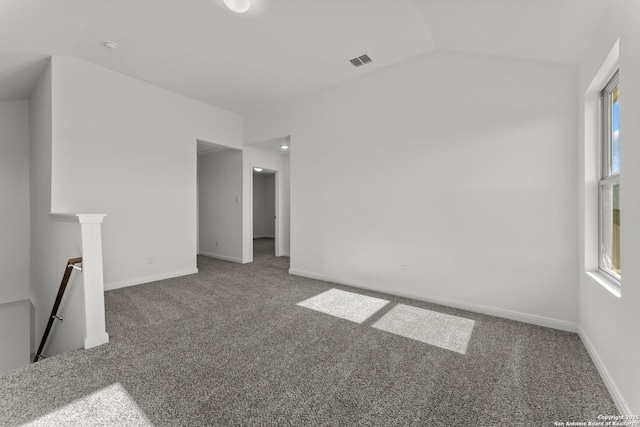 unfurnished room with lofted ceiling, carpet, visible vents, and baseboards