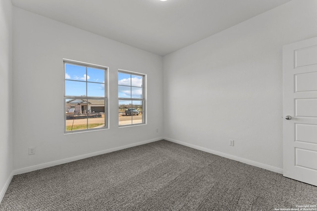 spare room featuring carpet flooring and baseboards