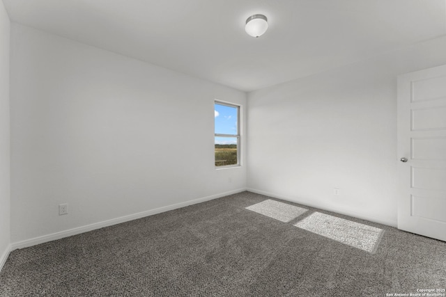 unfurnished room featuring carpet and baseboards