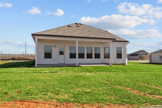 rear view of property featuring a yard, a patio, and roof with shingles