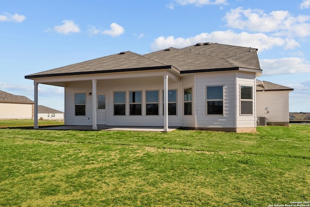 rear view of property featuring cooling unit, a patio area, and a yard