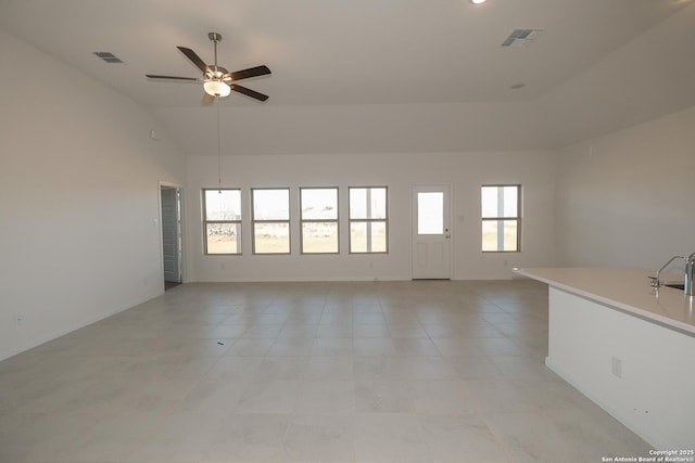 unfurnished living room featuring a ceiling fan, vaulted ceiling, visible vents, and a sink