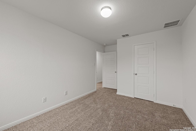 unfurnished bedroom featuring a textured ceiling and carpet