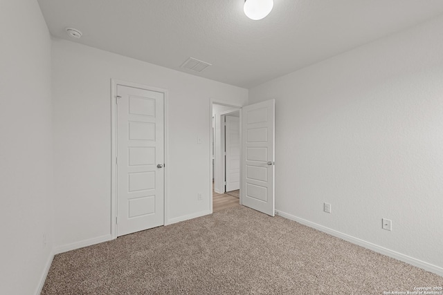 carpeted spare room with a textured ceiling