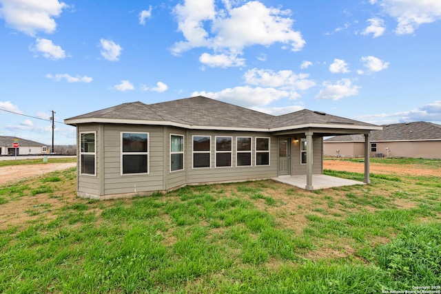 back of property featuring a lawn and a patio