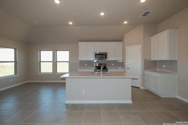 kitchen with stainless steel appliances, sink, a center island with sink, and white cabinets