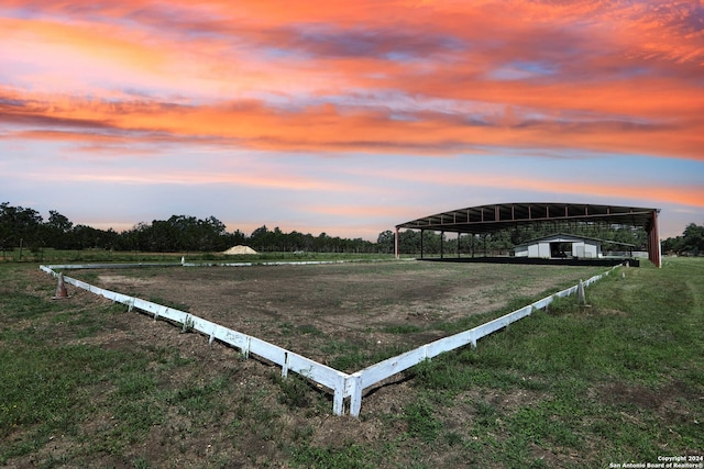 yard at dusk with a rural view and a carport