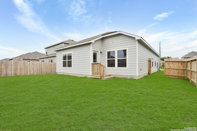 rear view of property with a yard