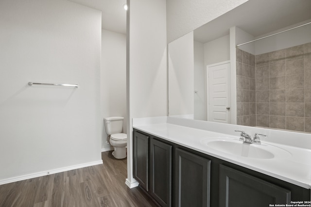 bathroom with hardwood / wood-style floors, toilet, and vanity