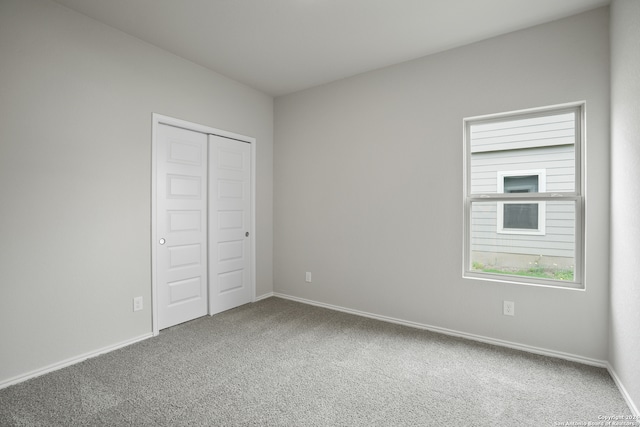 unfurnished bedroom featuring carpet and a closet