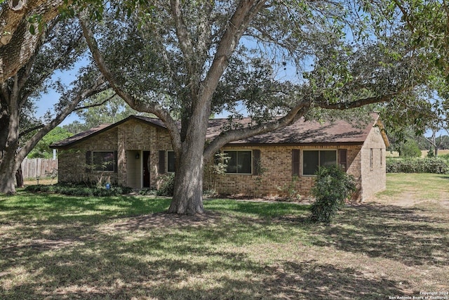 view of front of home featuring brick siding, a front yard, and fence