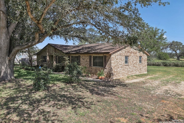 view of front of property with a front lawn and brick siding