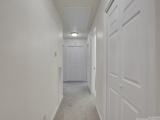 hall with light colored carpet