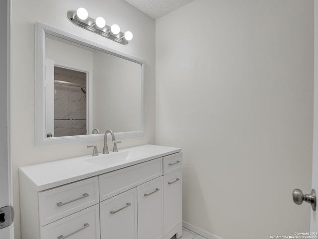 bathroom with a textured ceiling and vanity