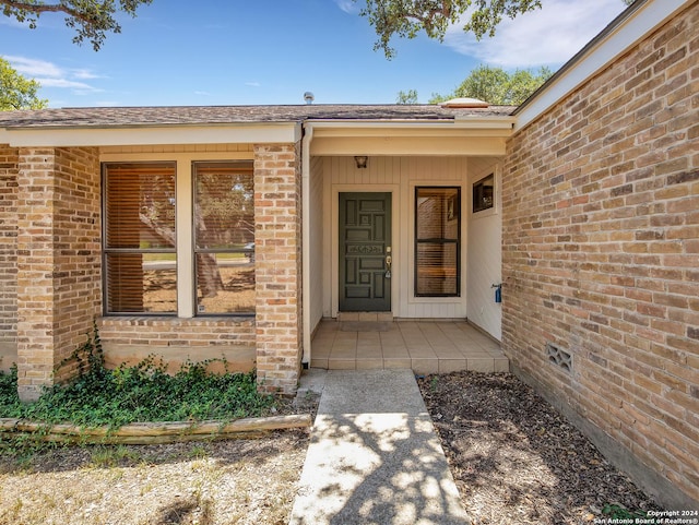 entrance to property with a patio area and brick siding