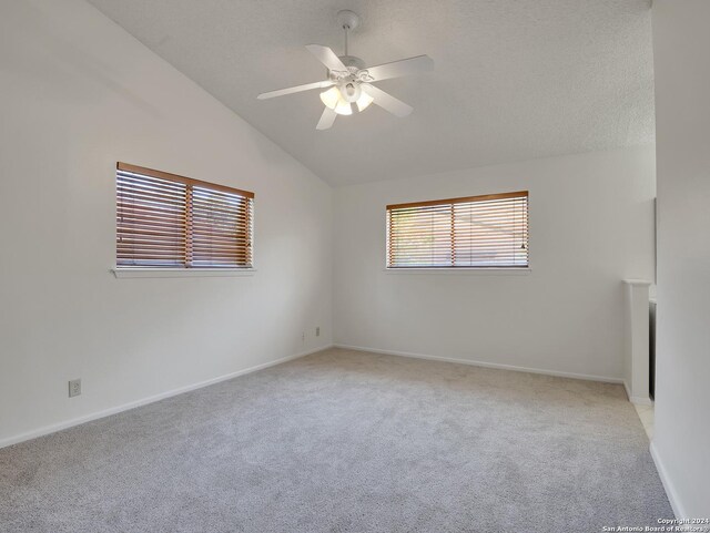 unfurnished room with light colored carpet, lofted ceiling, and ceiling fan