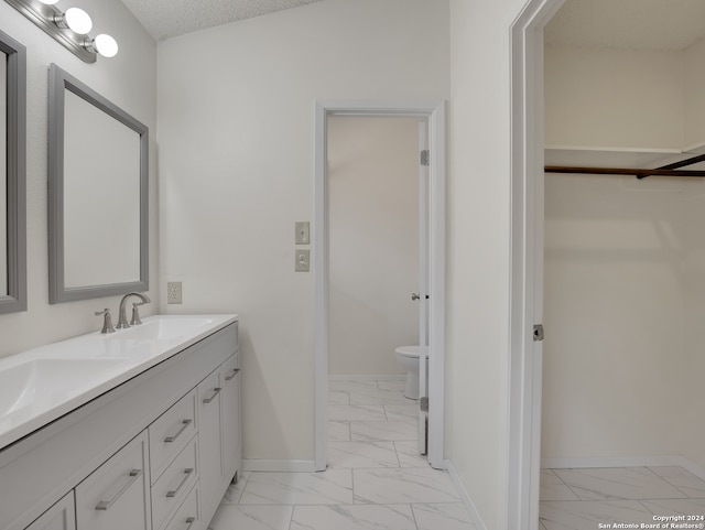 bathroom featuring toilet, tile patterned flooring, double vanity, a textured ceiling, and lofted ceiling