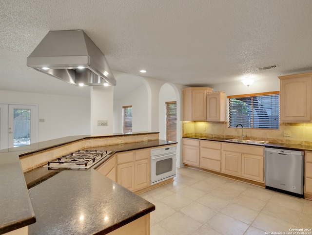 kitchen with appliances with stainless steel finishes, plenty of natural light, extractor fan, and light brown cabinets