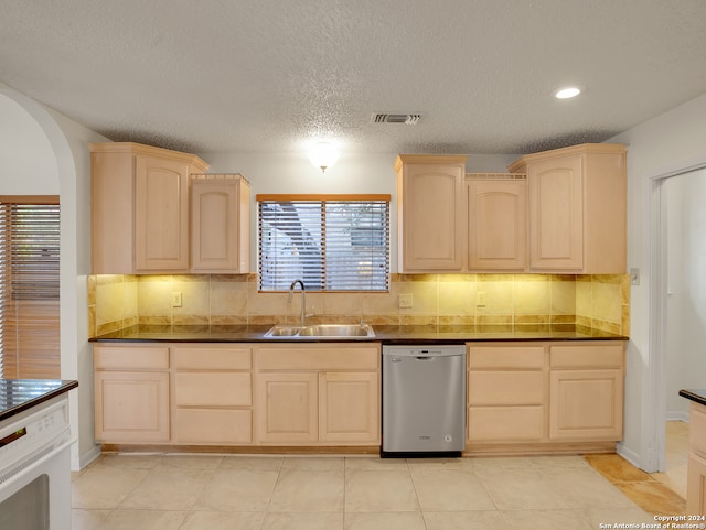 kitchen with sink, dishwasher, decorative backsplash, and light brown cabinets