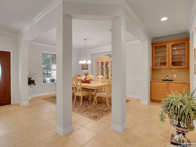 dining room featuring light tile patterned floors, crown molding, and a notable chandelier