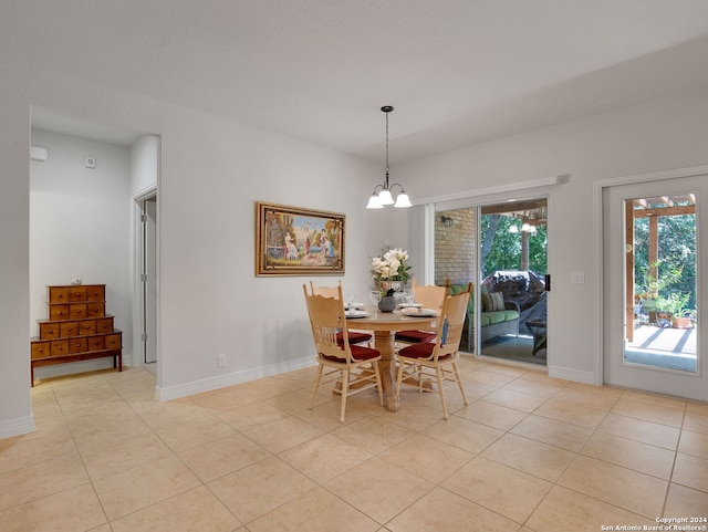 tiled dining space featuring an inviting chandelier