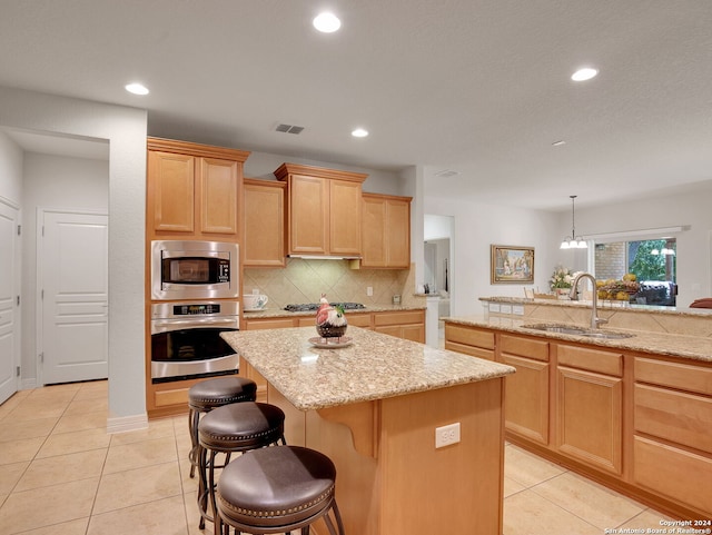 kitchen featuring appliances with stainless steel finishes, a kitchen island, and sink