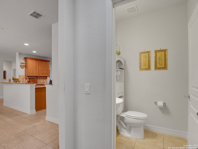 bathroom featuring toilet and tile patterned flooring