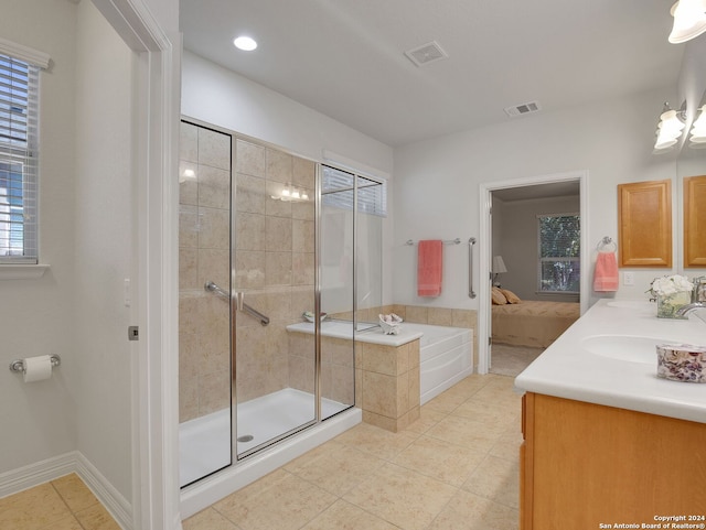 bathroom featuring shower with separate bathtub, vanity, and tile patterned floors